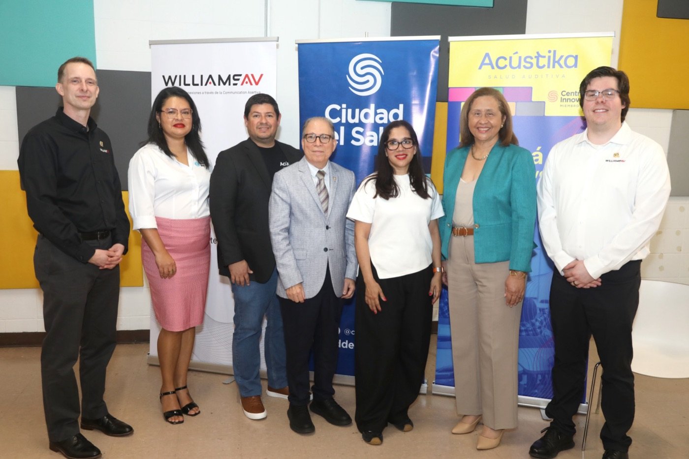 Equipo de Acústika y aliados frente a banners de Williams AV, Ciudad del Saber y Acústika