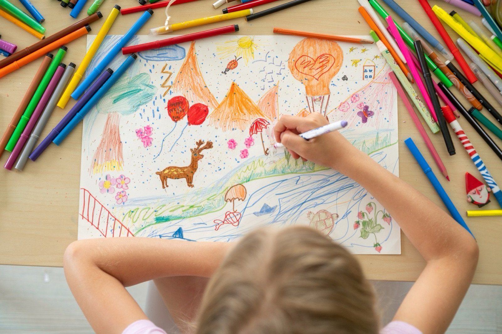 Niña dibujando con lápices de colores