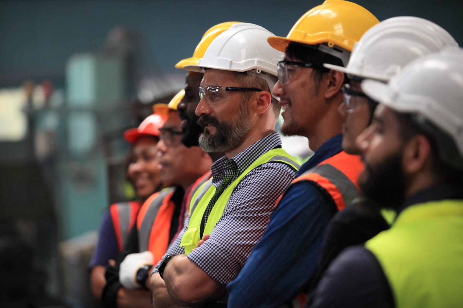 Trabajadores con cascos y chalecos en una reunión