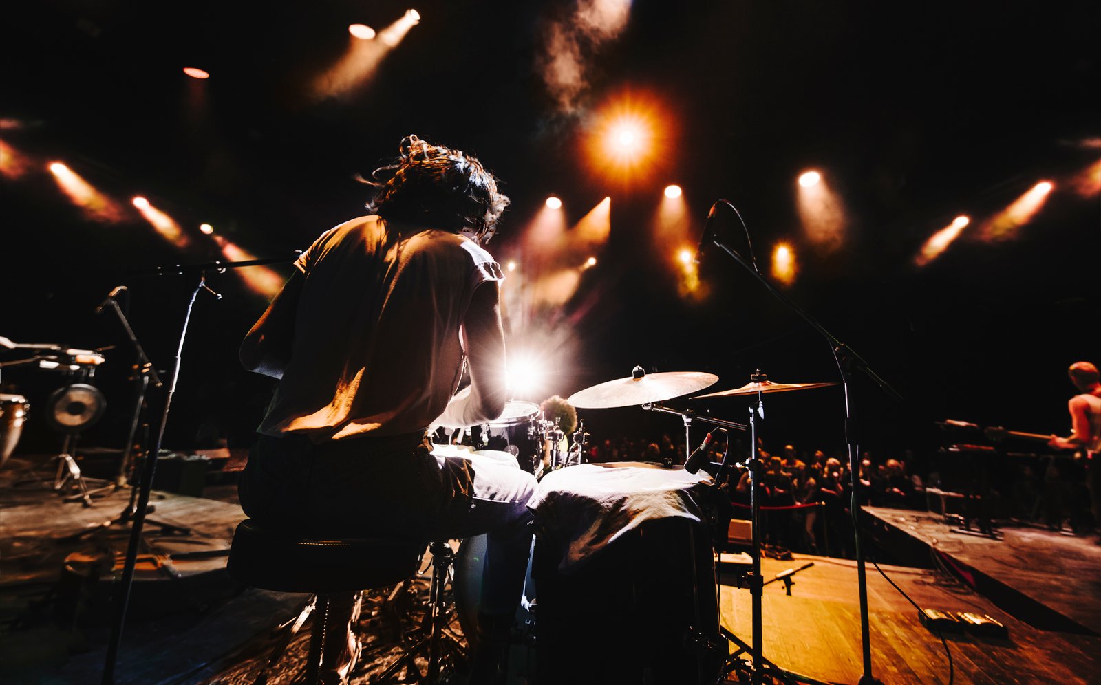 Baterista tocando en un escenario con luces